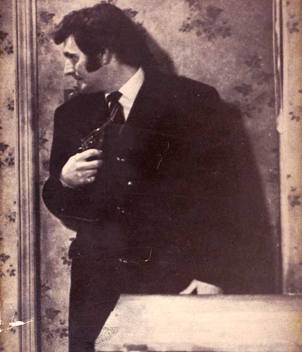 Big Bread Winner Hog Granada TV close up of sean glenn acting in the sixties big breadwinner with back to a floral patterned papered wall with gun grasped against his body in a very tense sean
