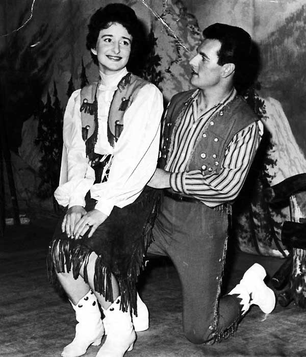 glenn on stage on one knee with his leading lady on his other knee both wearing country and western clothing in black and white